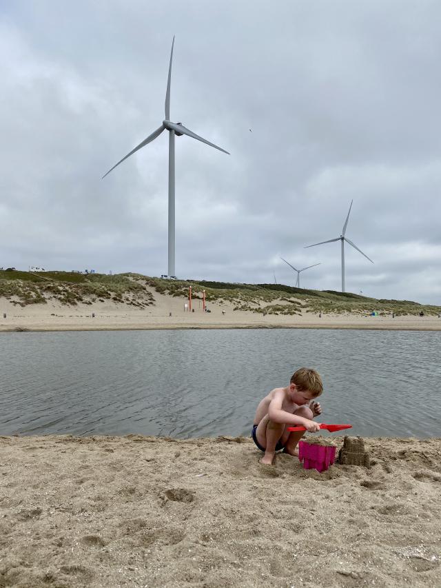 jongen speelt op het strand