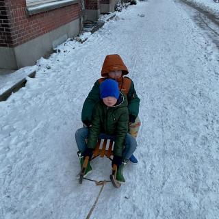 jongens op de slee in de sneeuw