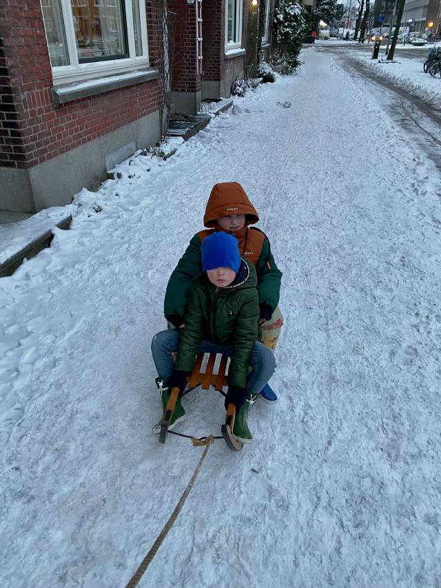 jongens op de slee in de sneeuw