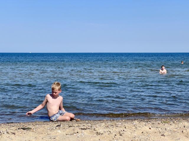 jongen speelt op het strand