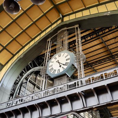 een klok hangt temidden van de stalen constructie van het stationsgebouw van Hamburg